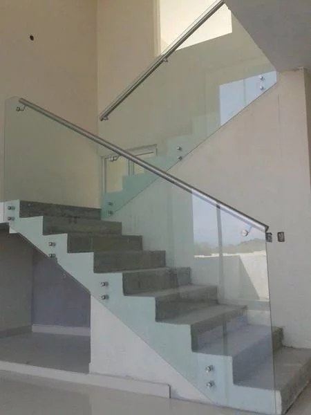 Baranda de vidrio con pasamanos de acero inoxidable fijada con botones al lateral de la escalera · MÁS VIDRIOS