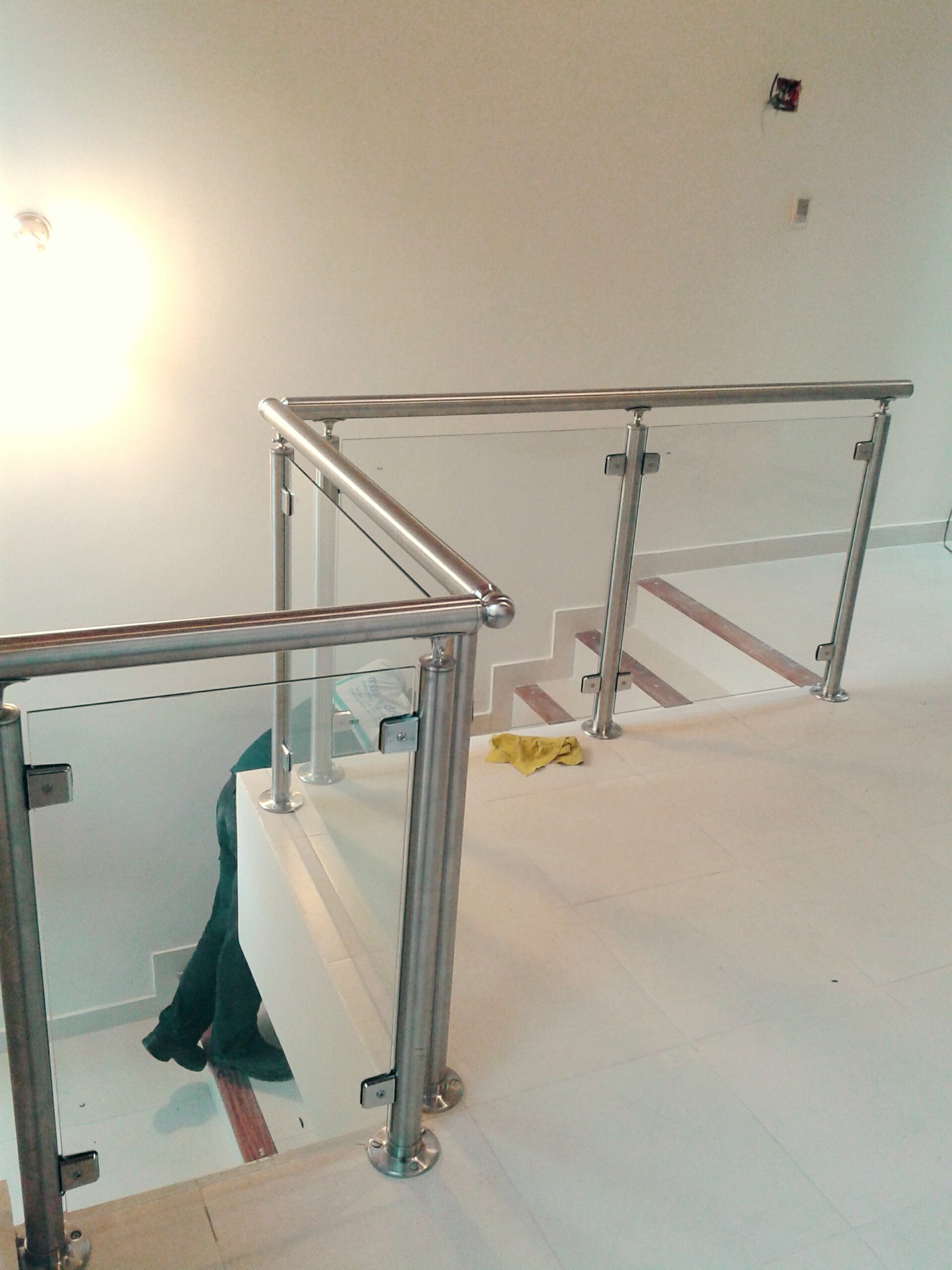 Baranda de vidrio con parantes y pasamanos de acero inoxidable en el descanso de una escalera · MÁS VIDRIOS