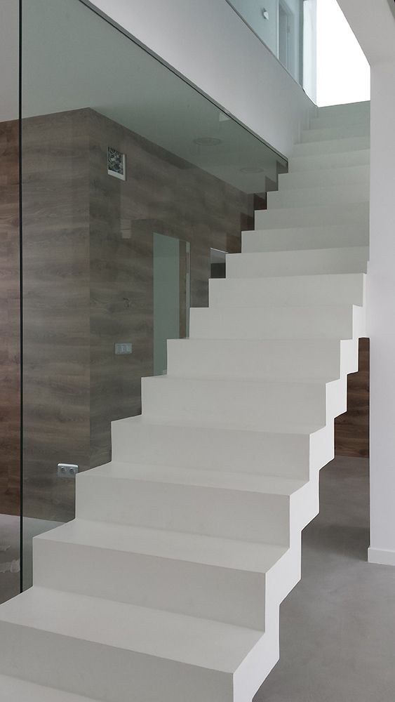 Baranda de vidrio en escalera blanca con revestimiento de madera · MÁS VIDRIOS