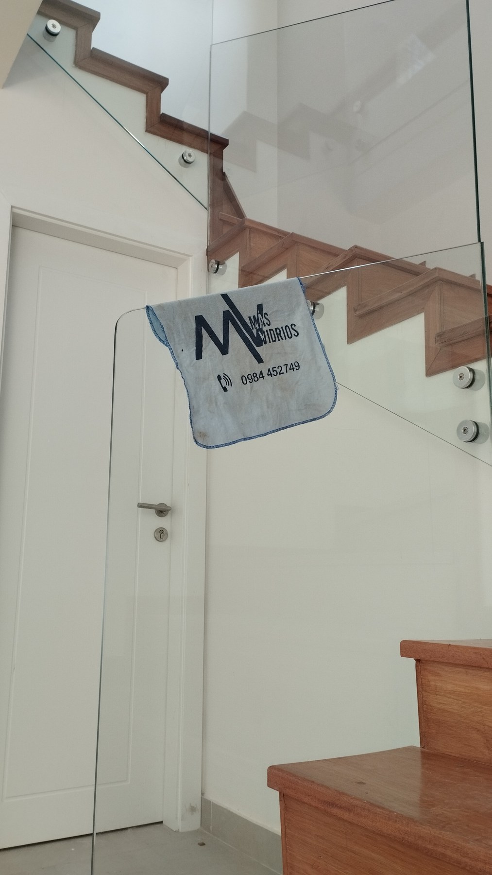 Baranda de vidrio en escalera interior de madera con botones de fijación a la pared · MÁS VIDRIOS