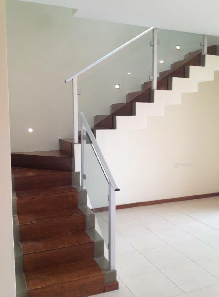 Baranda de vidrio con pasamanos de acero inoxidable en escalera de peldaños de madera · MÁS VIDRIOS