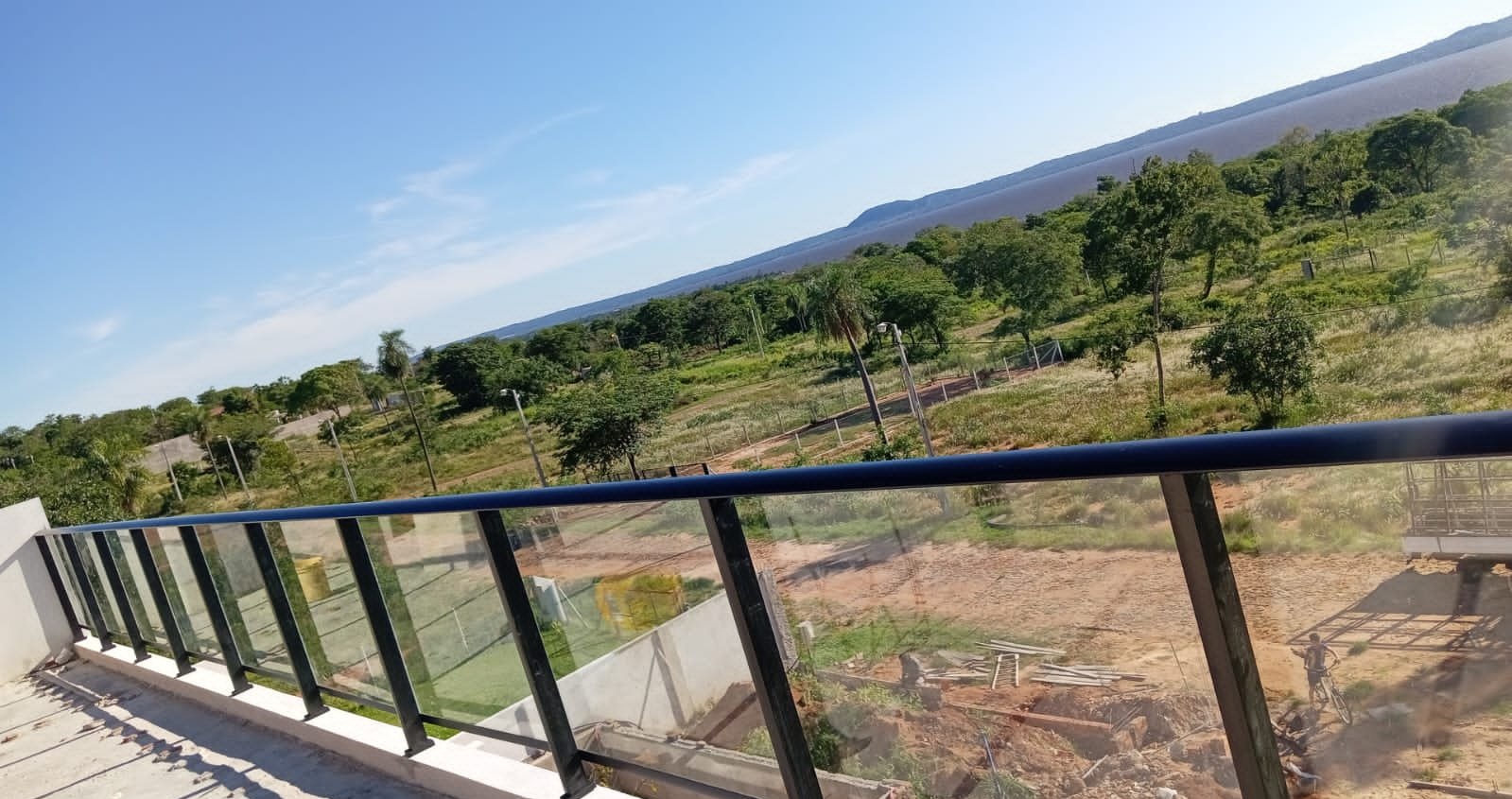 Baranda de vidrio con parantes y pasamanos de aluminio negro en balcón con vista al lago · MÁS VIDRIOS