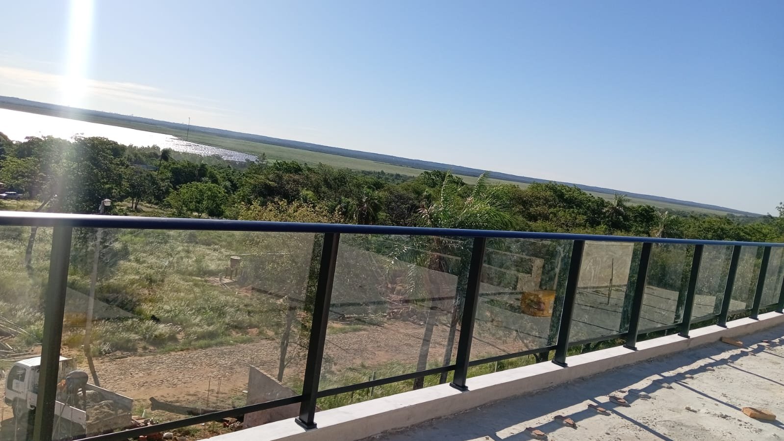 Baranda de vidrio con perfilería de aluminio negro en terraza panorámica sobre el río · MÁS VIDRIOS