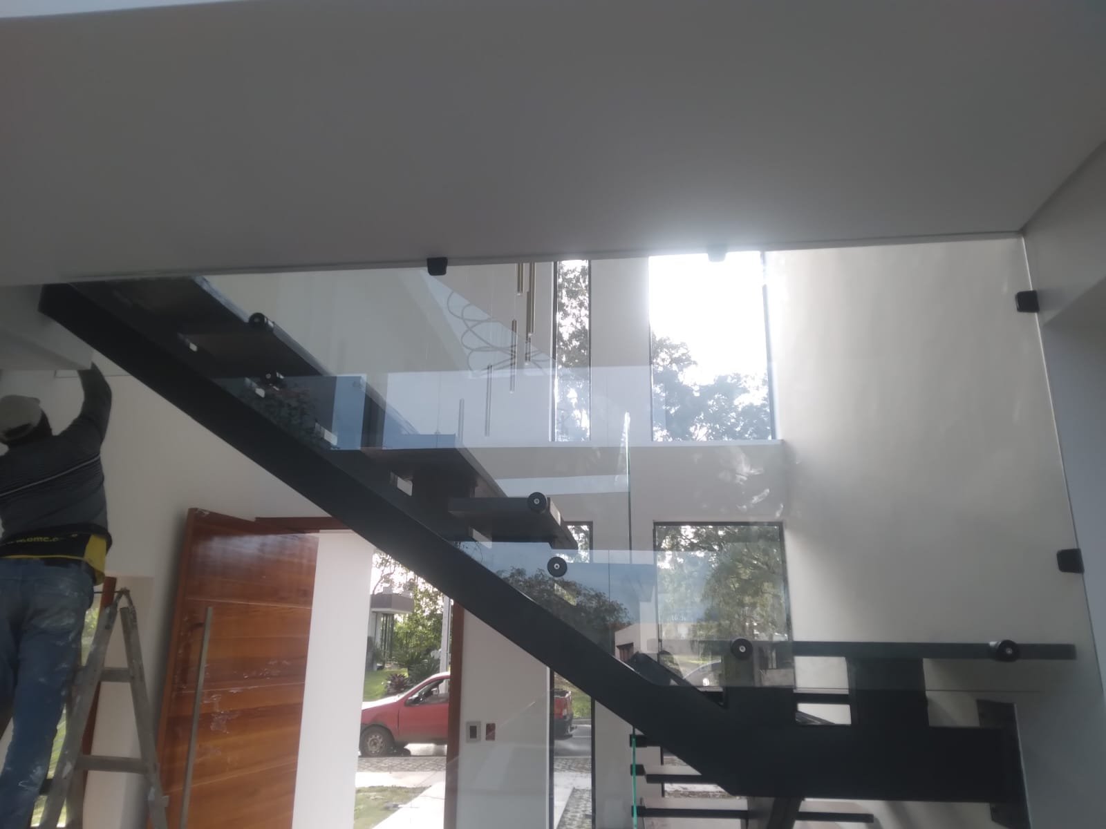 Baranda de vidrio templado con botones sobre escalera metálica negra · MÁS VIDRIOS