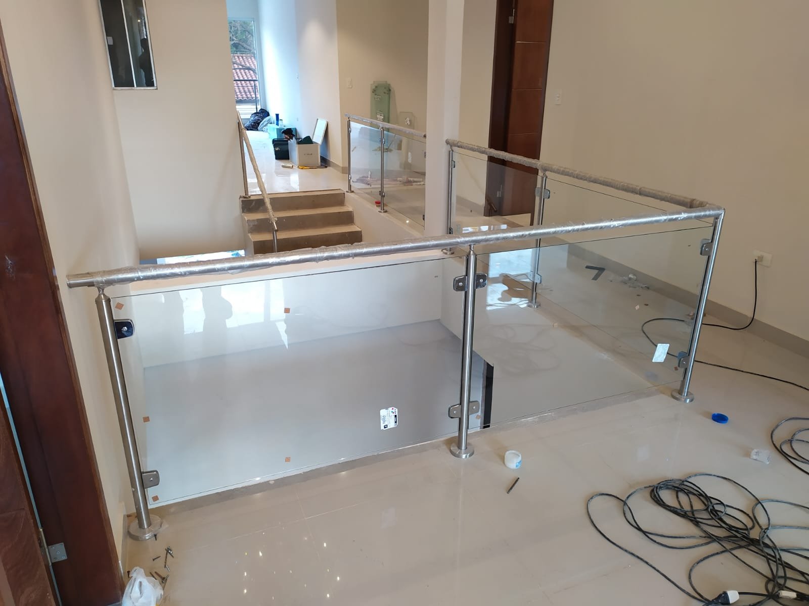Baranda de vidrio con parantes de acero inoxidable en entrepiso residencial · MÁS VIDRIOS