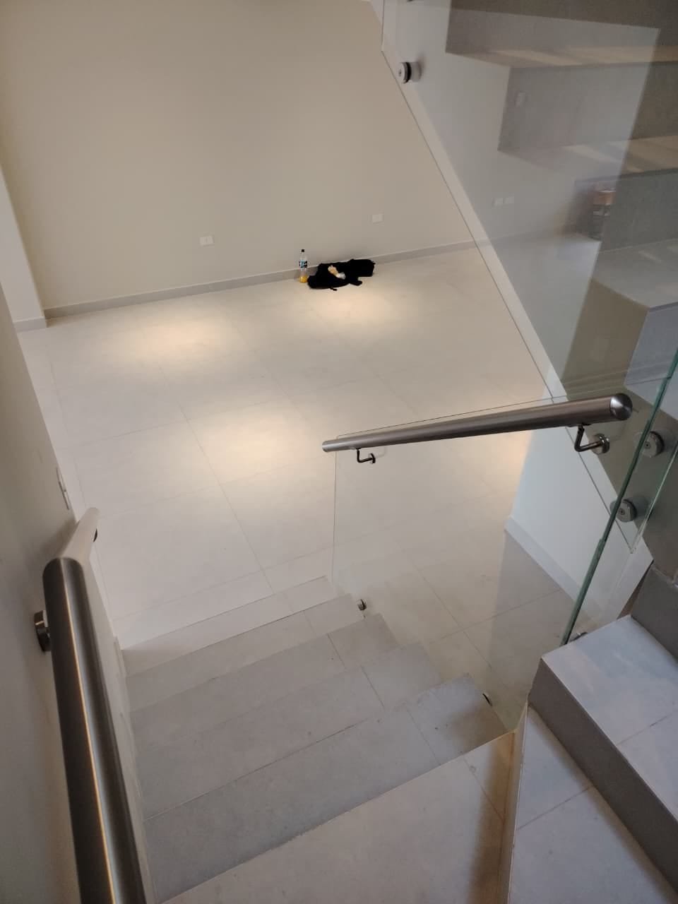 Baranda de vidrio templado con pasamanos de acero inoxidable en escalera de porcelanato · MÁS VIDRIOS