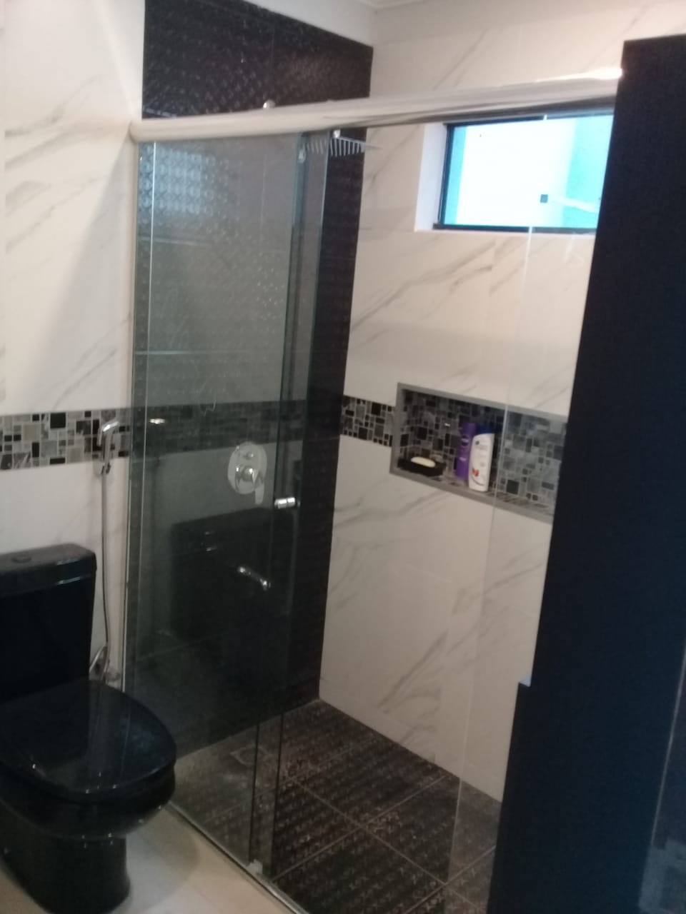 Box de ducha corredizo en vidrio transparente sobre baño con guarda de mosaicos · MÁS VIDRIOS