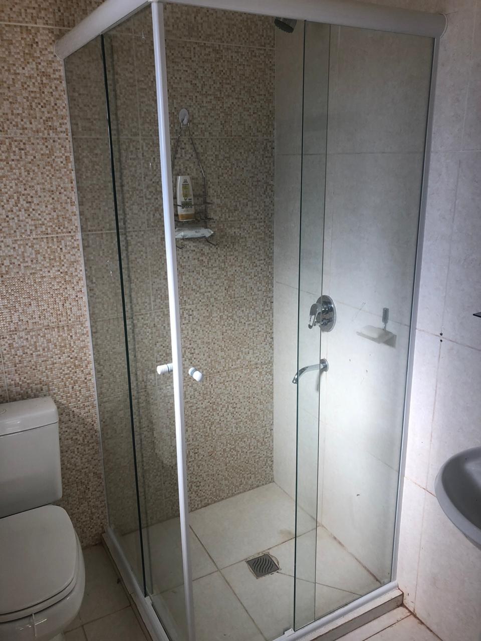 Box de ducha de esquina en vidrio transparente con perfilería blanca · MÁS VIDRIOS