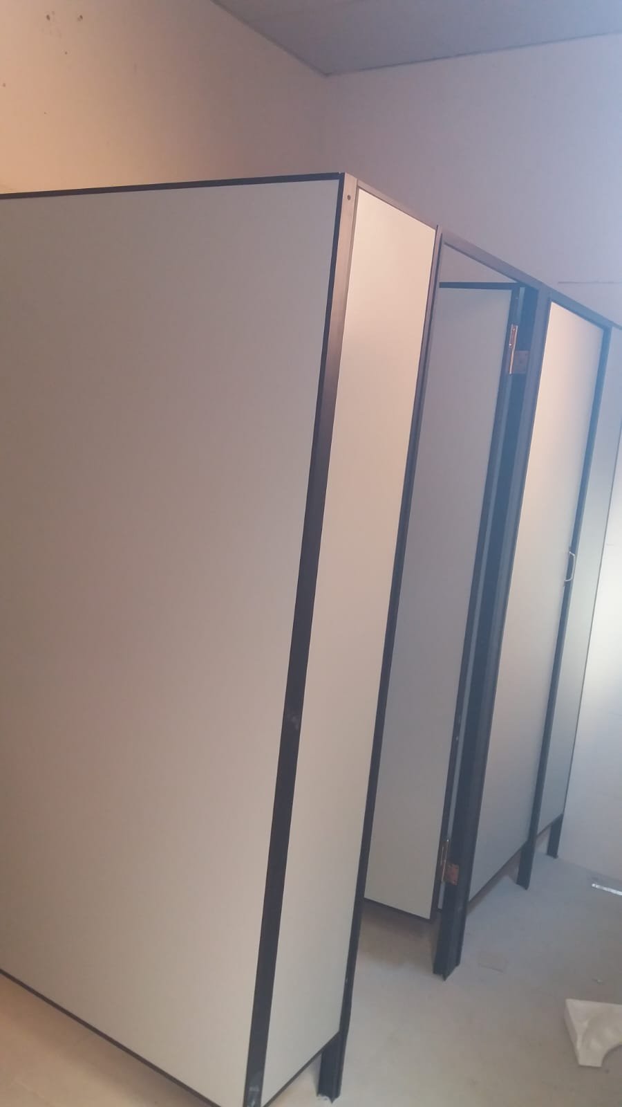 Cabinas de sanitario en Eucatex con canto y parantes negros · MÁS VIDRIOS
