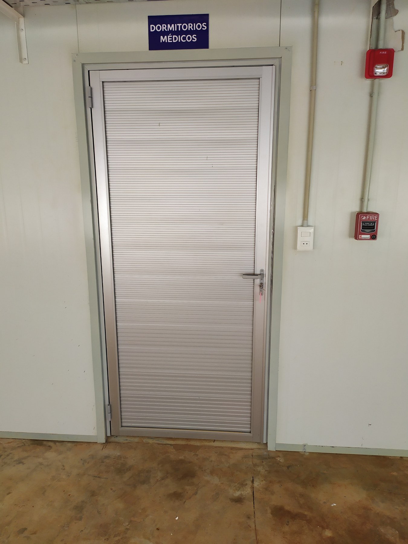 Paño de celosía de aluminio blanco montado en un tabique de panel · MÁS VIDRIOS