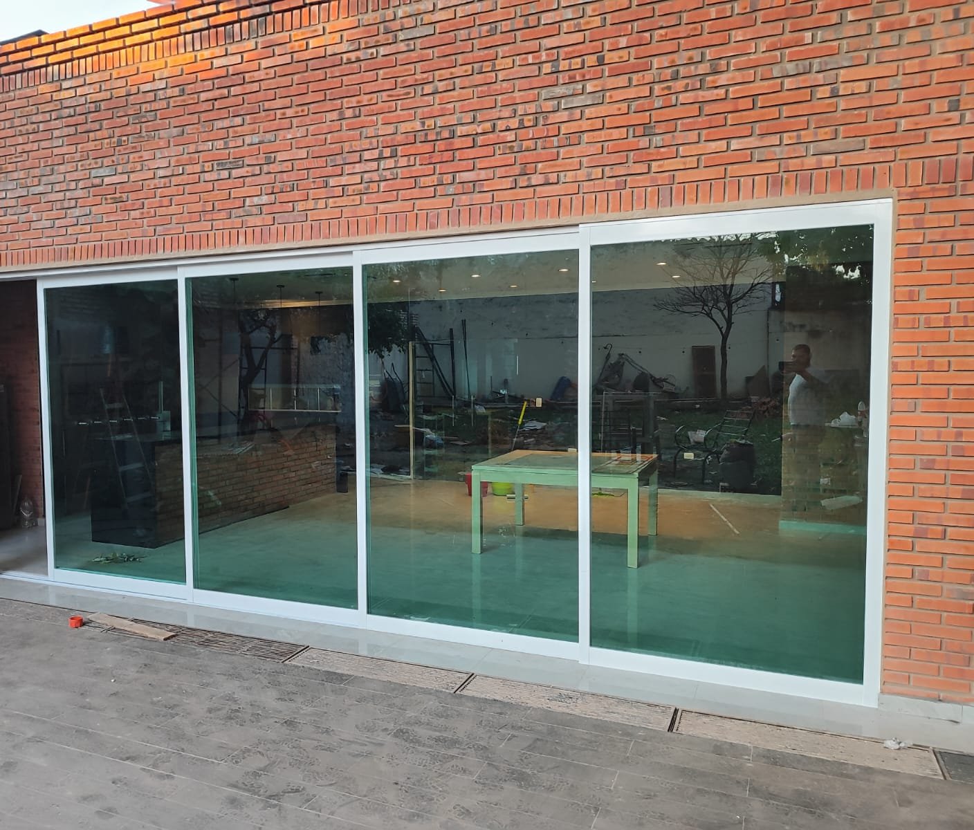 Cerramiento de vidrio con perfiles de aluminio blanco en quincho de ladrillo visto · MÁS VIDRIOS