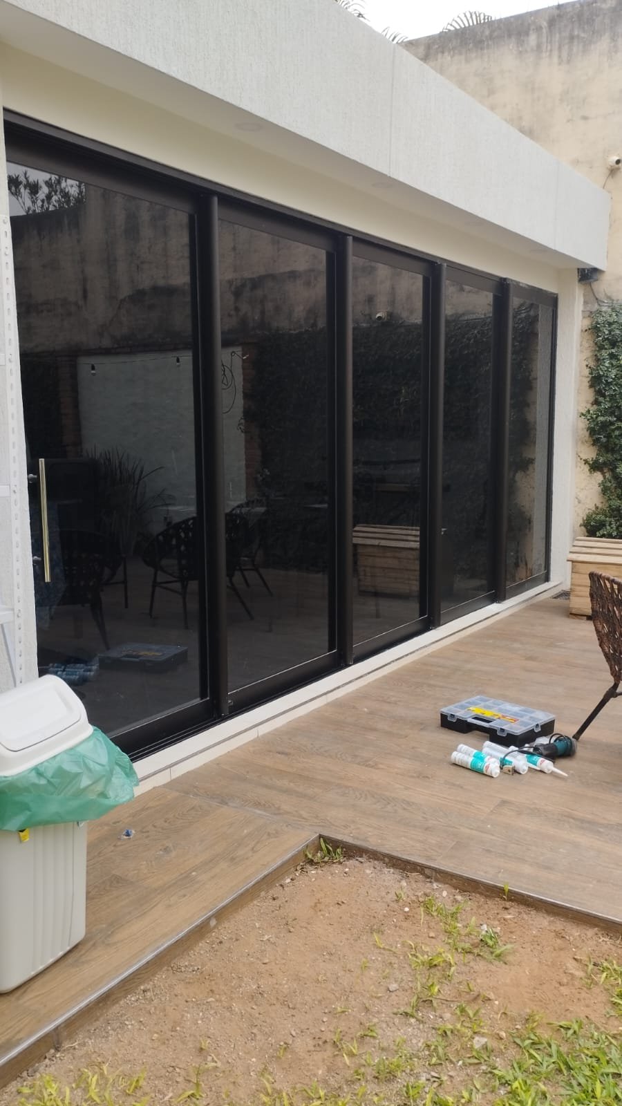 Cerramiento de vidrio con hojas corredizas de aluminio negro para quincho · MÁS VIDRIOS