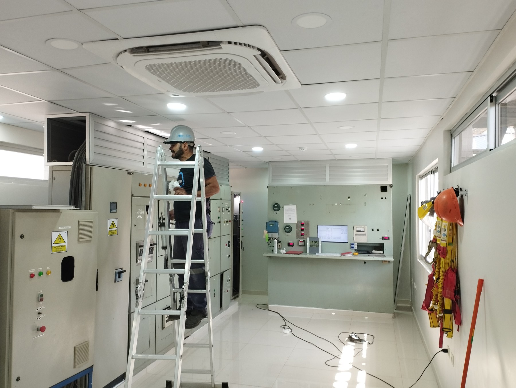 Cielo raso desmontable con luminarias embutidas y equipo de aire en sala de tableros eléctricos · MÁS VIDRIOS