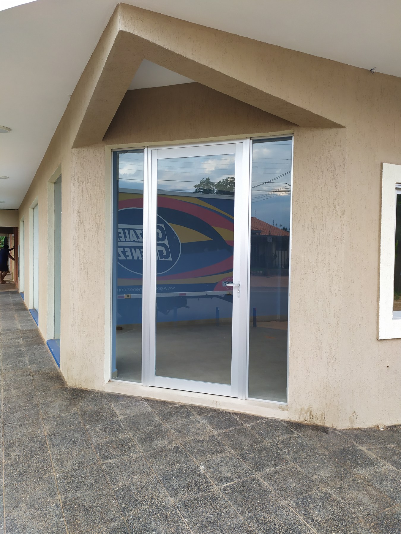 Abertura corrediza de aluminio blanco con vidrio en el frente de un local · MÁS VIDRIOS
