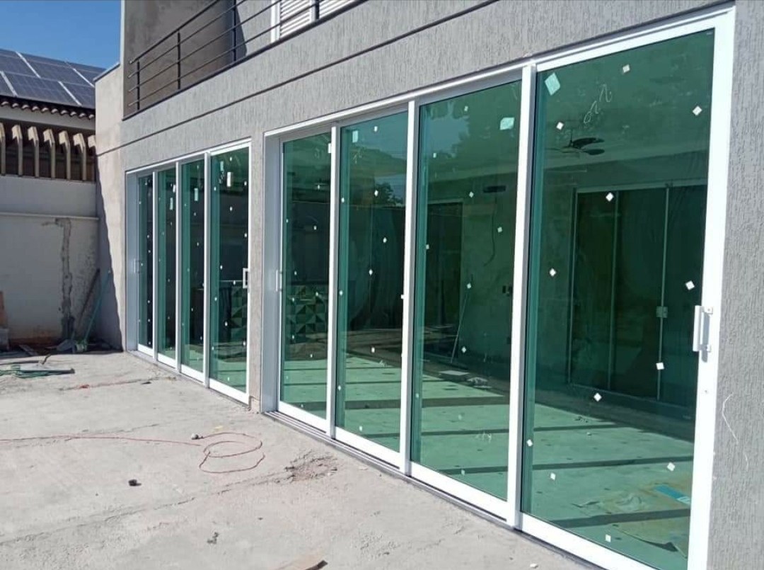 Puertas corredizas de aluminio con vidrio en fachada de vivienda · MÁS VIDRIOS