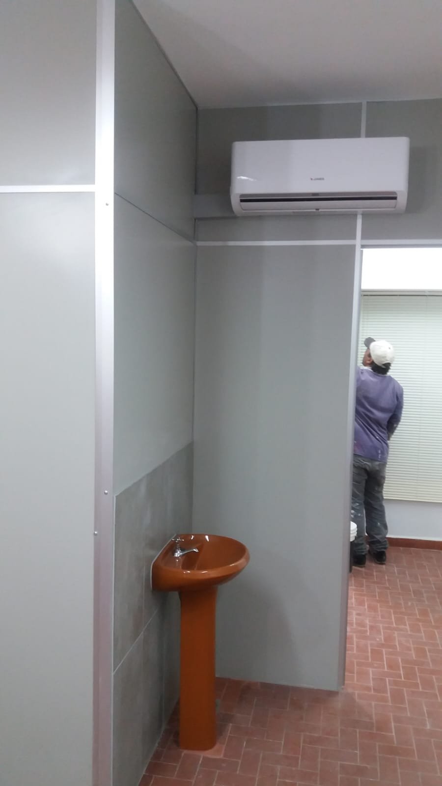 División de baño en paneles de Eucatex con perfilería de aluminio, junto al lavatorio · MÁS VIDRIOS