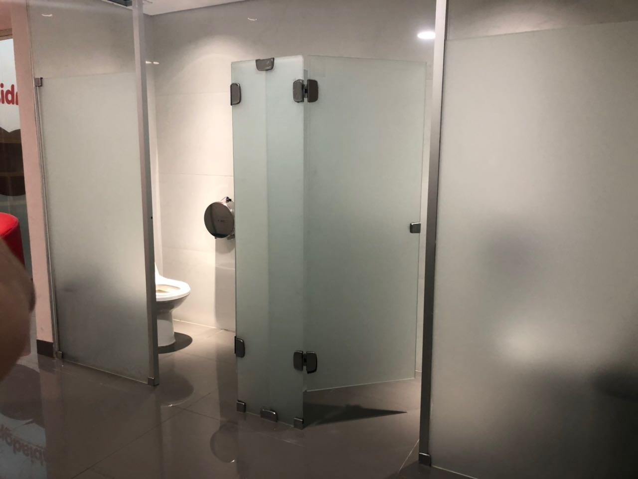 División de sanitarios en vidrio ploteado con herrajes negros · MÁS VIDRIOS