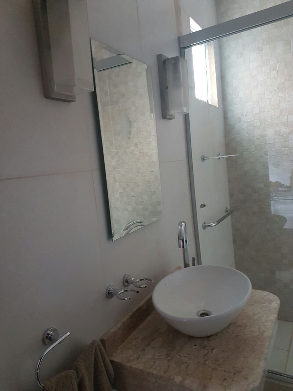 Espejo con canto pulido sobre mesada de granito con bacha de apoyo en baño con mampara de vidrio · MÁS VIDRIOS