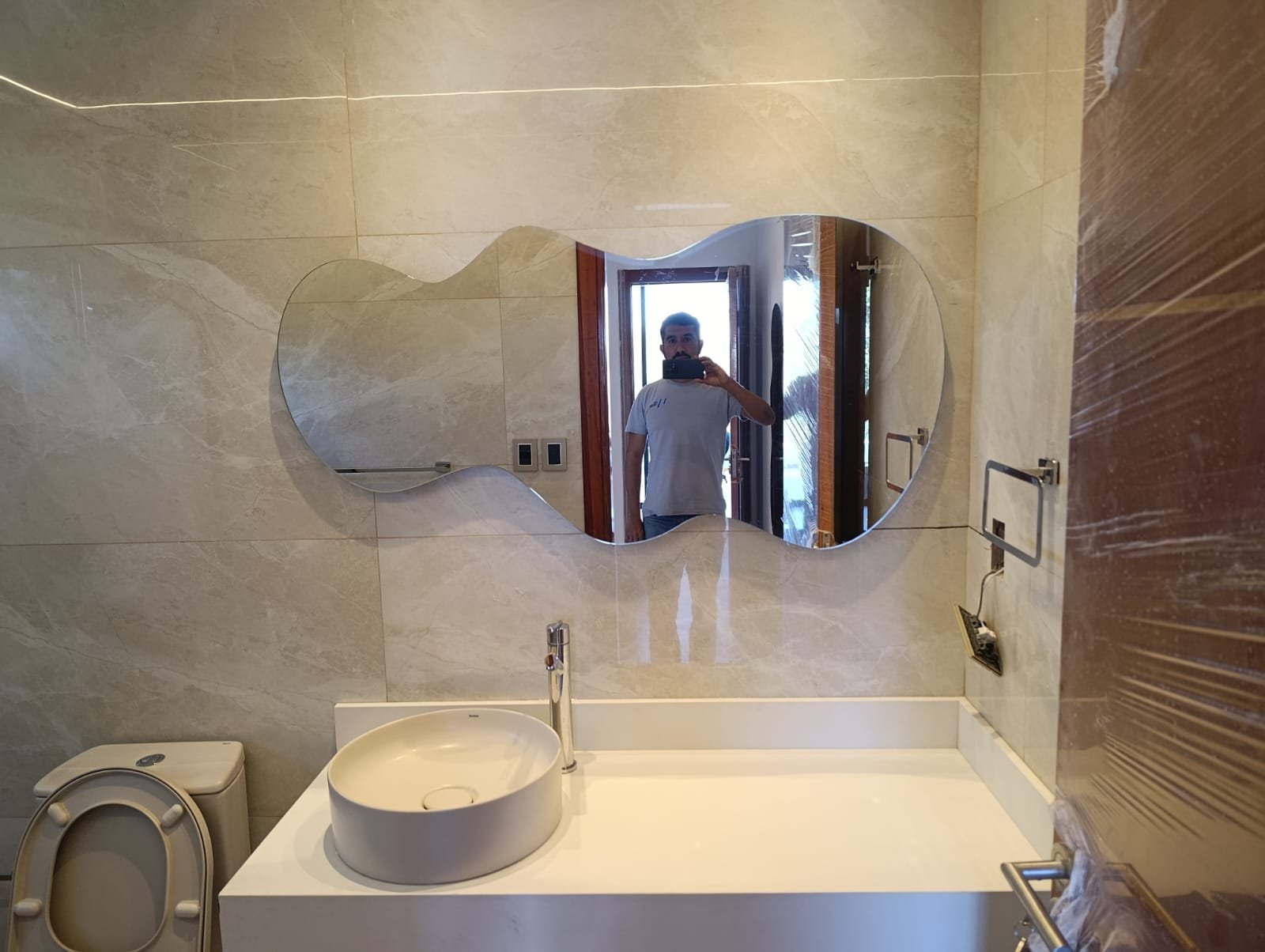 Espejo de forma orgánica sin marco en baño moderno · MÁS VIDRIOS