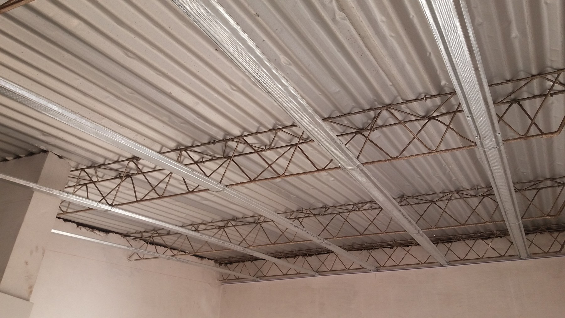 Estructura de perfiles del cielo raso montada bajo techo de chapa · MÁS VIDRIOS