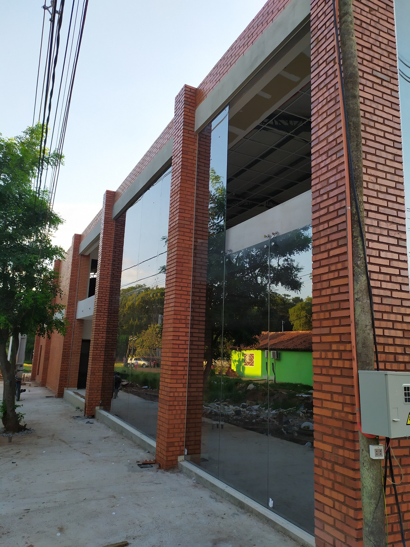 Fachada vidriada de dos plantas con paños entre columnas de ladrillo visto · MÁS VIDRIOS