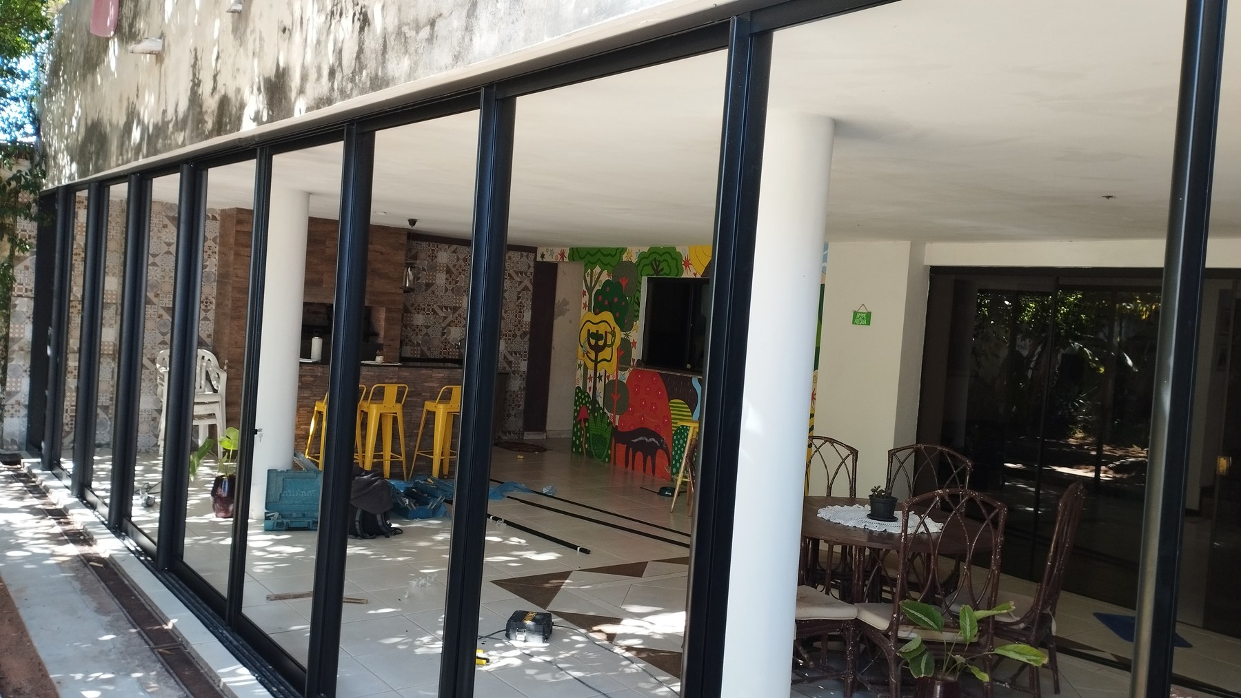 Frente corredizo de aluminio negro con vidrio en salón comercial · MÁS VIDRIOS