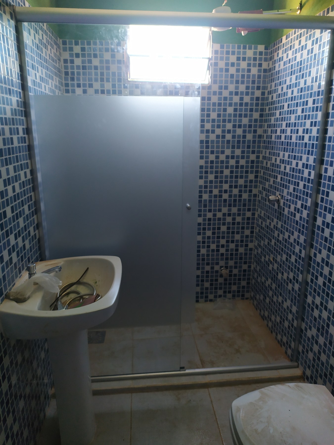Mampara fija de vidrio ploteado en baño con mosaicos azules · MÁS VIDRIOS