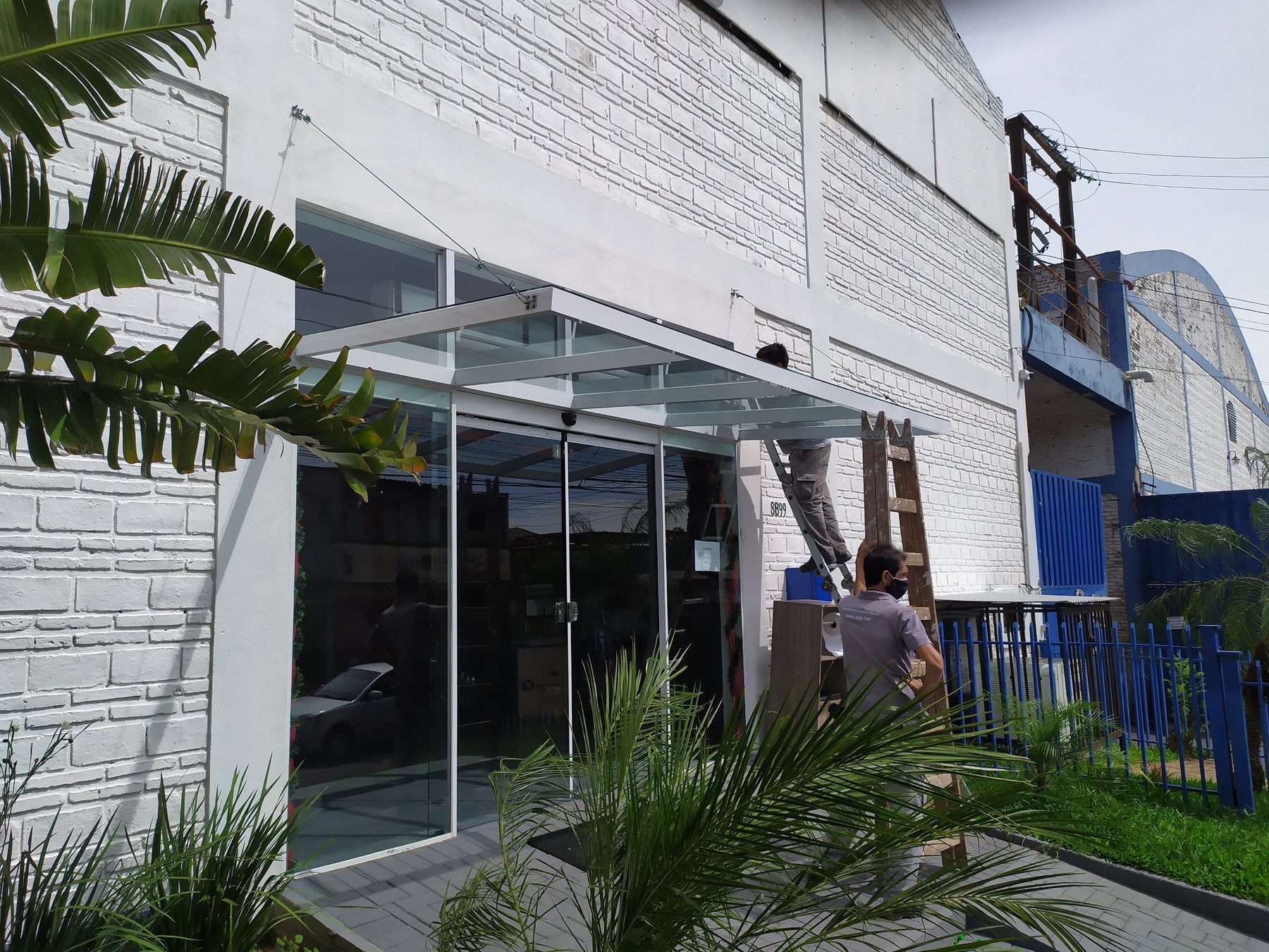 Marquesina de vidrio sobre el frente vidriado de un local comercial · MÁS VIDRIOS