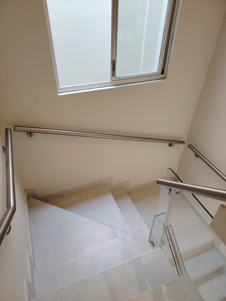 Pasamanos de acero inoxidable y baranda de vidrio en escalera interior · MÁS VIDRIOS