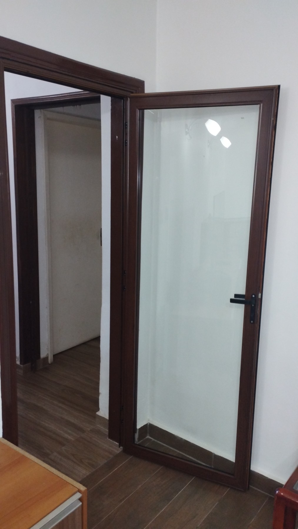 Puerta batiente de aluminio símil madera con vidrio ploteado en interior · MÁS VIDRIOS