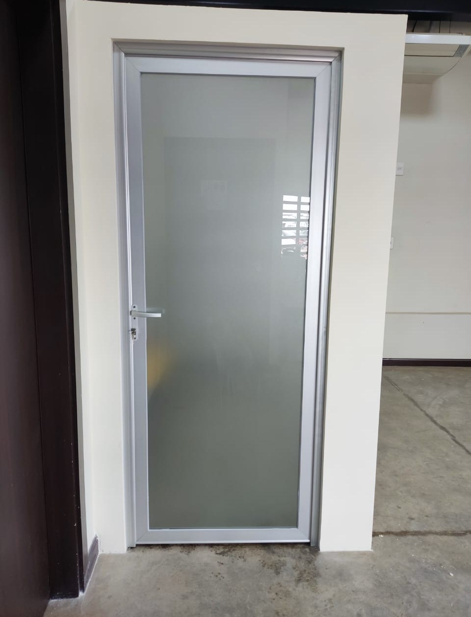 Puerta batiente de aluminio blanco con vidrio ploteado en ambiente interior · MÁS VIDRIOS