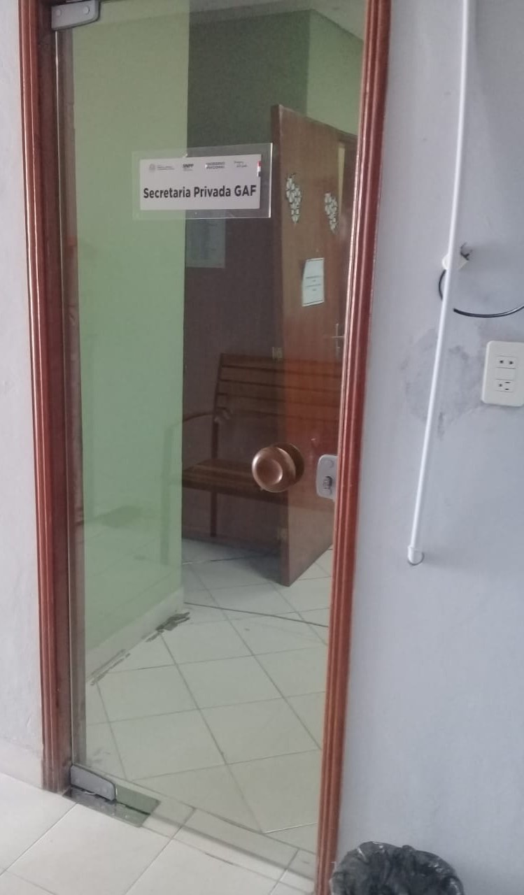 Puerta de vidrio con marco de aluminio color madera en oficina · MÁS VIDRIOS