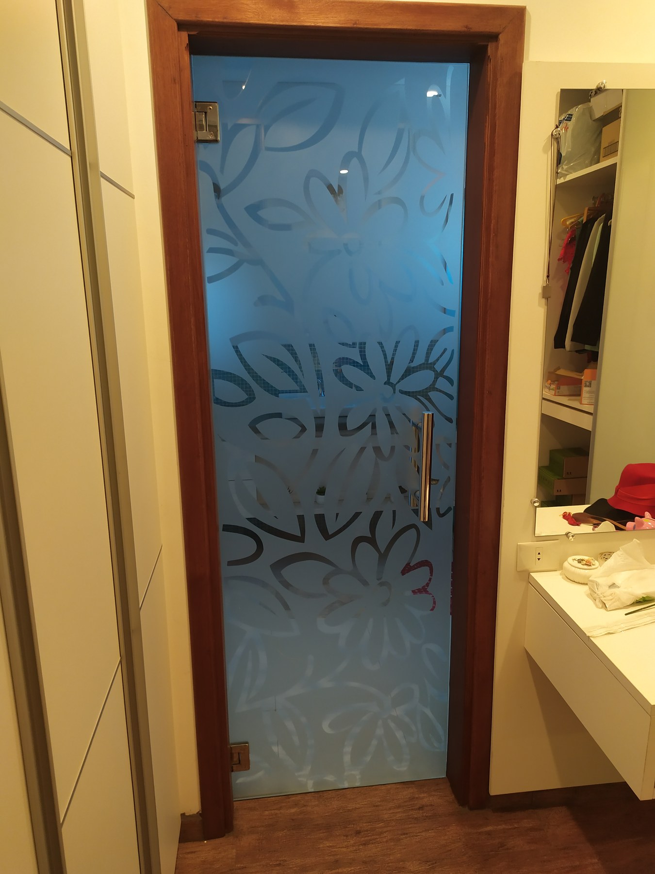 Puerta de vidrio ploteado con diseño floral en el acceso a un vestidor · MÁS VIDRIOS
