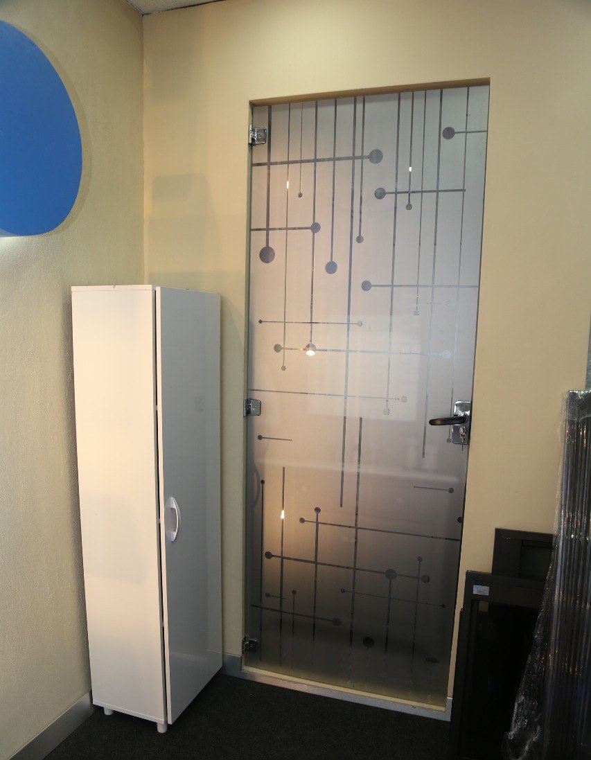 Puerta de vidrio ploteado con diseño de líneas y puntos en una oficina · MÁS VIDRIOS