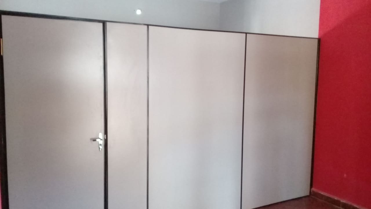 Tabique divisorio de placa Eucatex beige con puerta y perfilería de aluminio · MÁS VIDRIOS