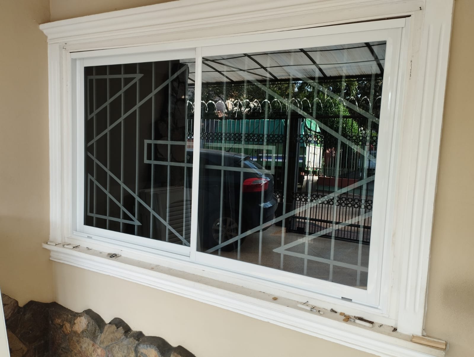 Ventana corrediza de aluminio blanco con reja decorativa · MÁS VIDRIOS