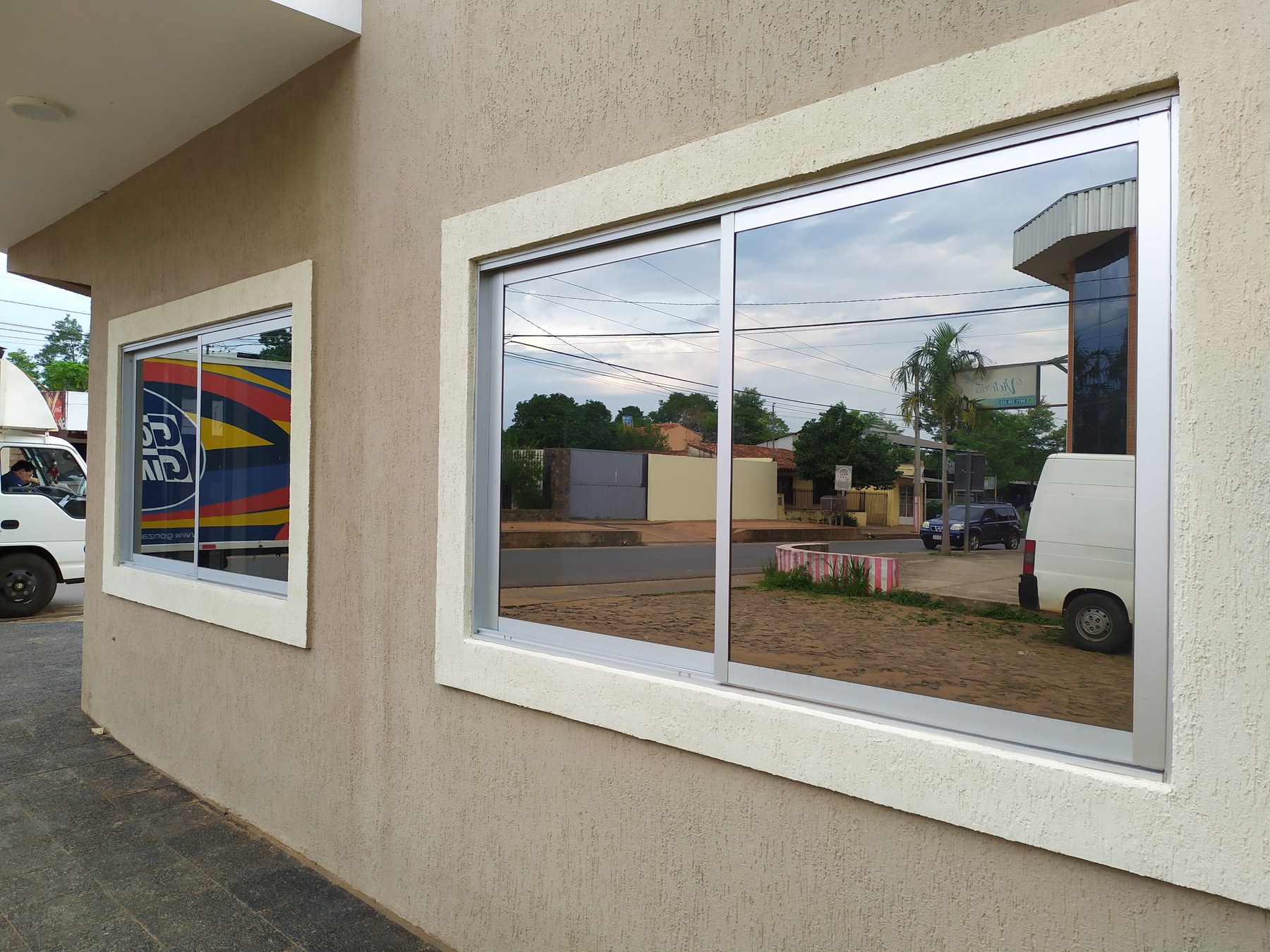 Ventana corrediza de aluminio blanco en el frente de un local comercial · MÁS VIDRIOS