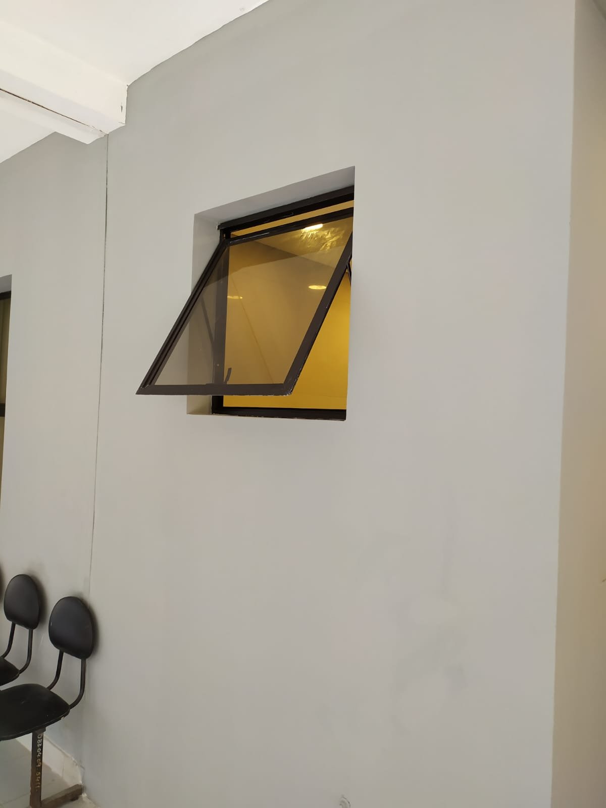 Ventana proyectante de vidrio bronce en sala de espera comercial · MÁS VIDRIOS