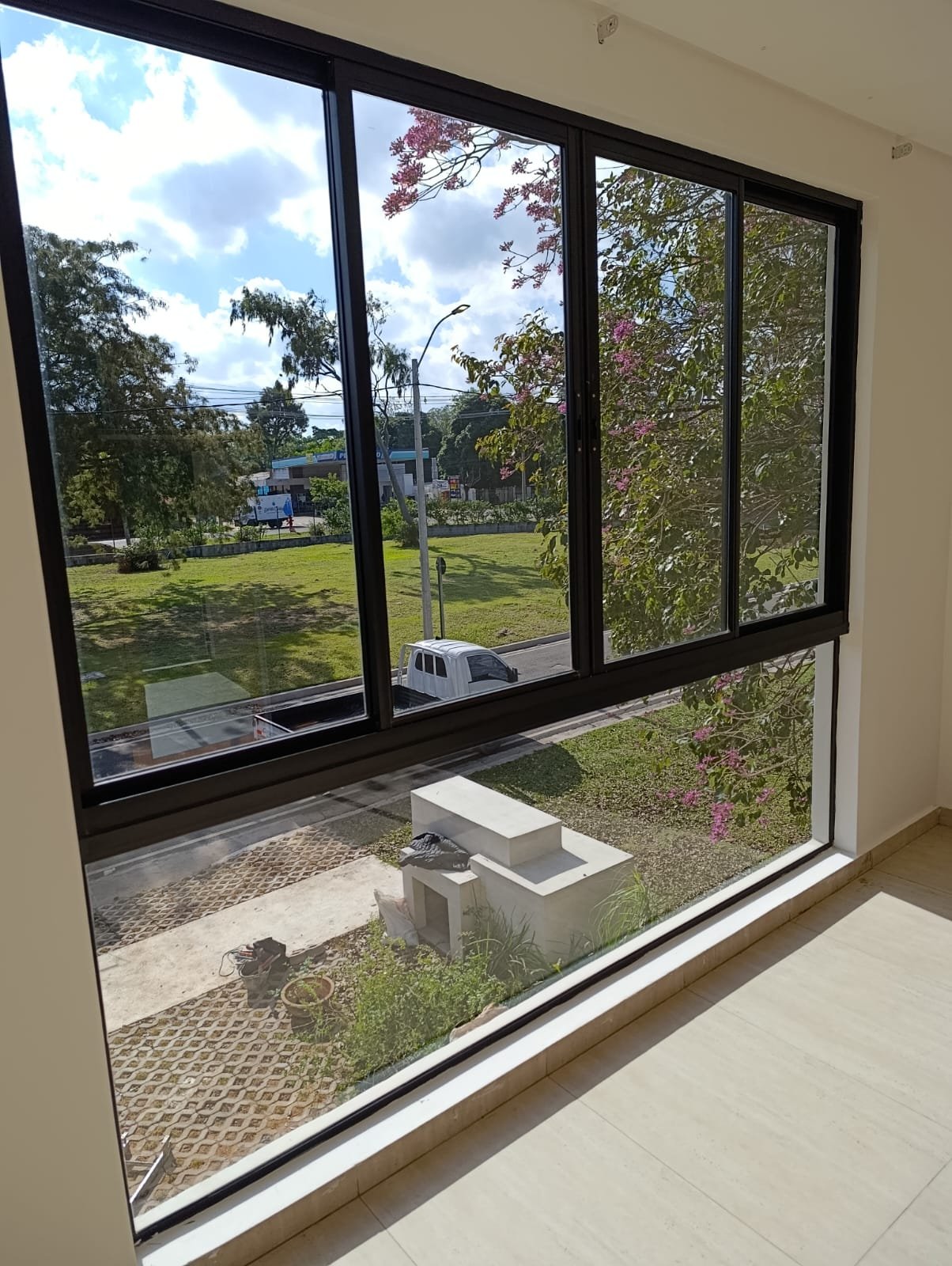 Ventanal corredizo de aluminio negro con paños fijos y vista al jardín · MÁS VIDRIOS