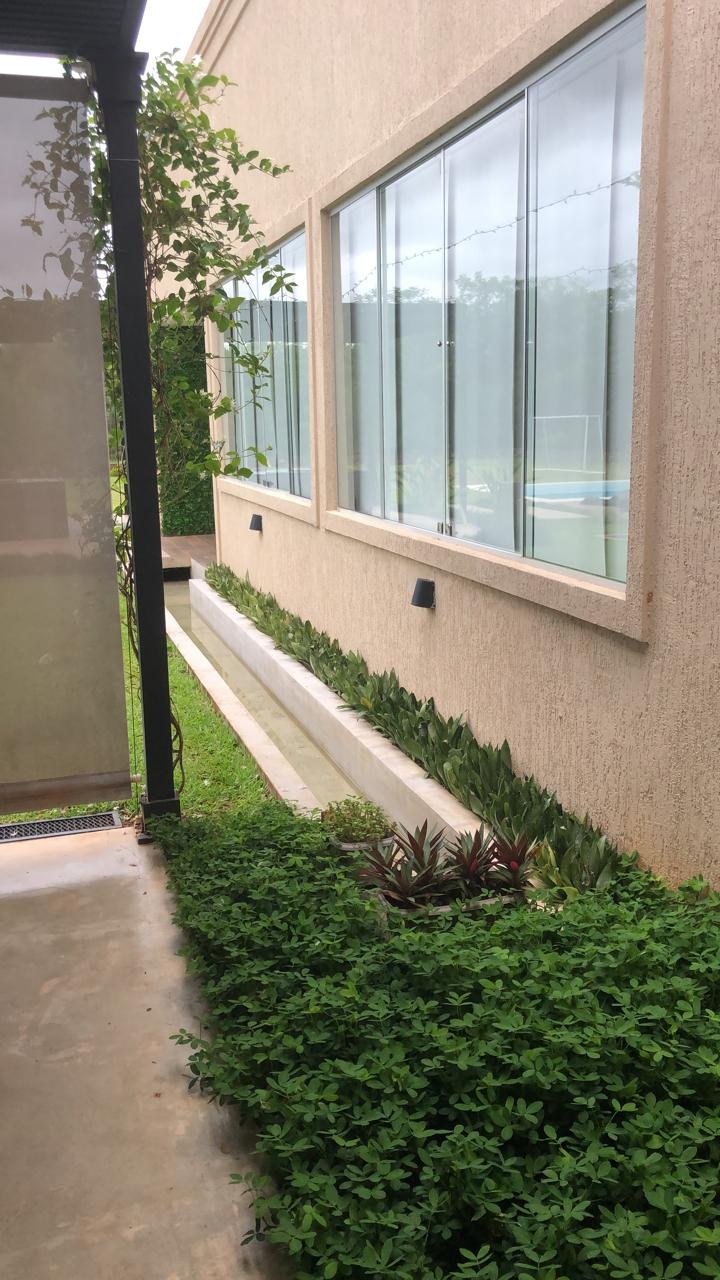 Ventanal corrido de aluminio blanco en el lateral de una casa, con jardín · MÁS VIDRIOS