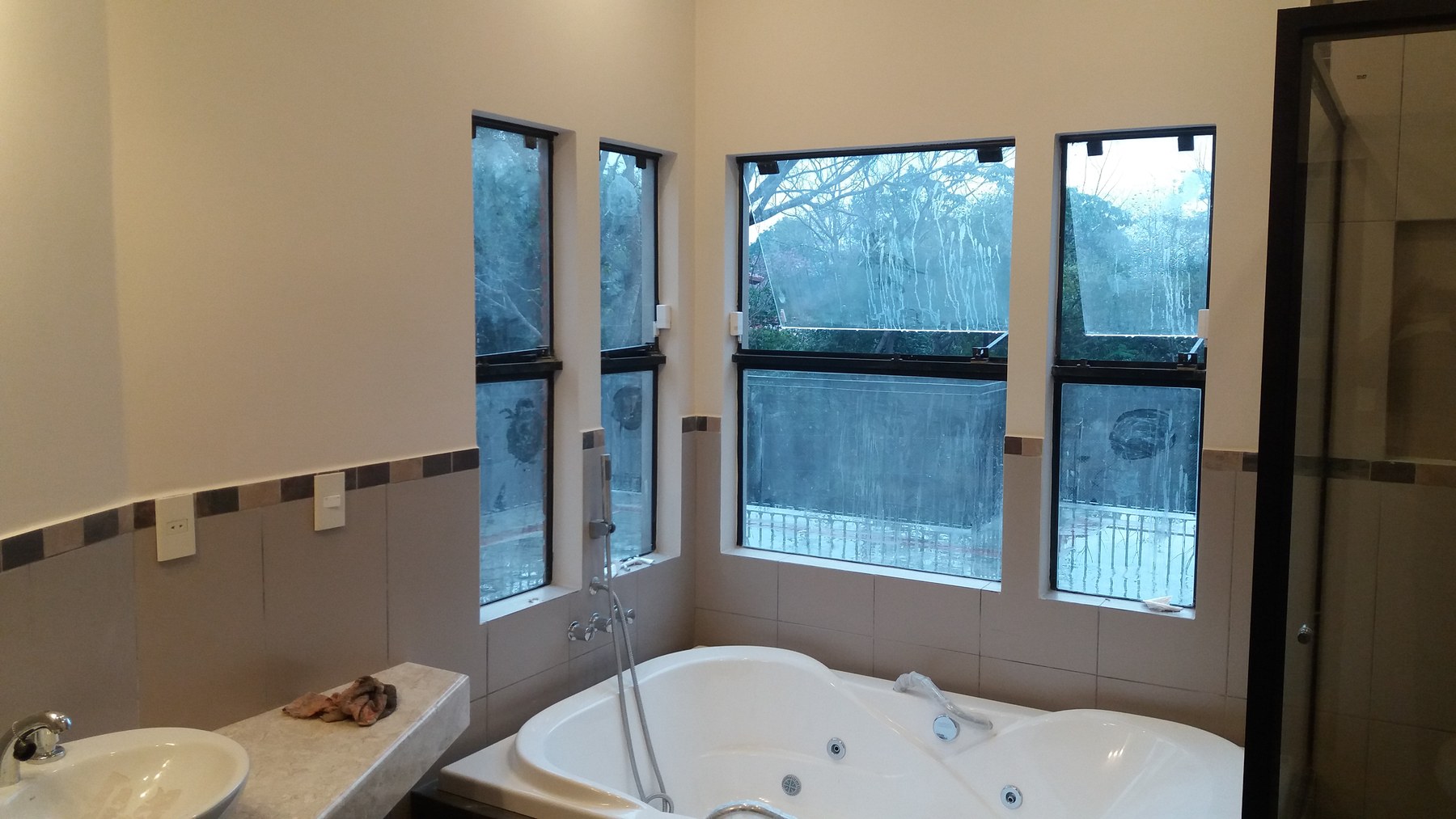 Ventanas de aluminio negro en baño con hidromasaje esquinero · MÁS VIDRIOS