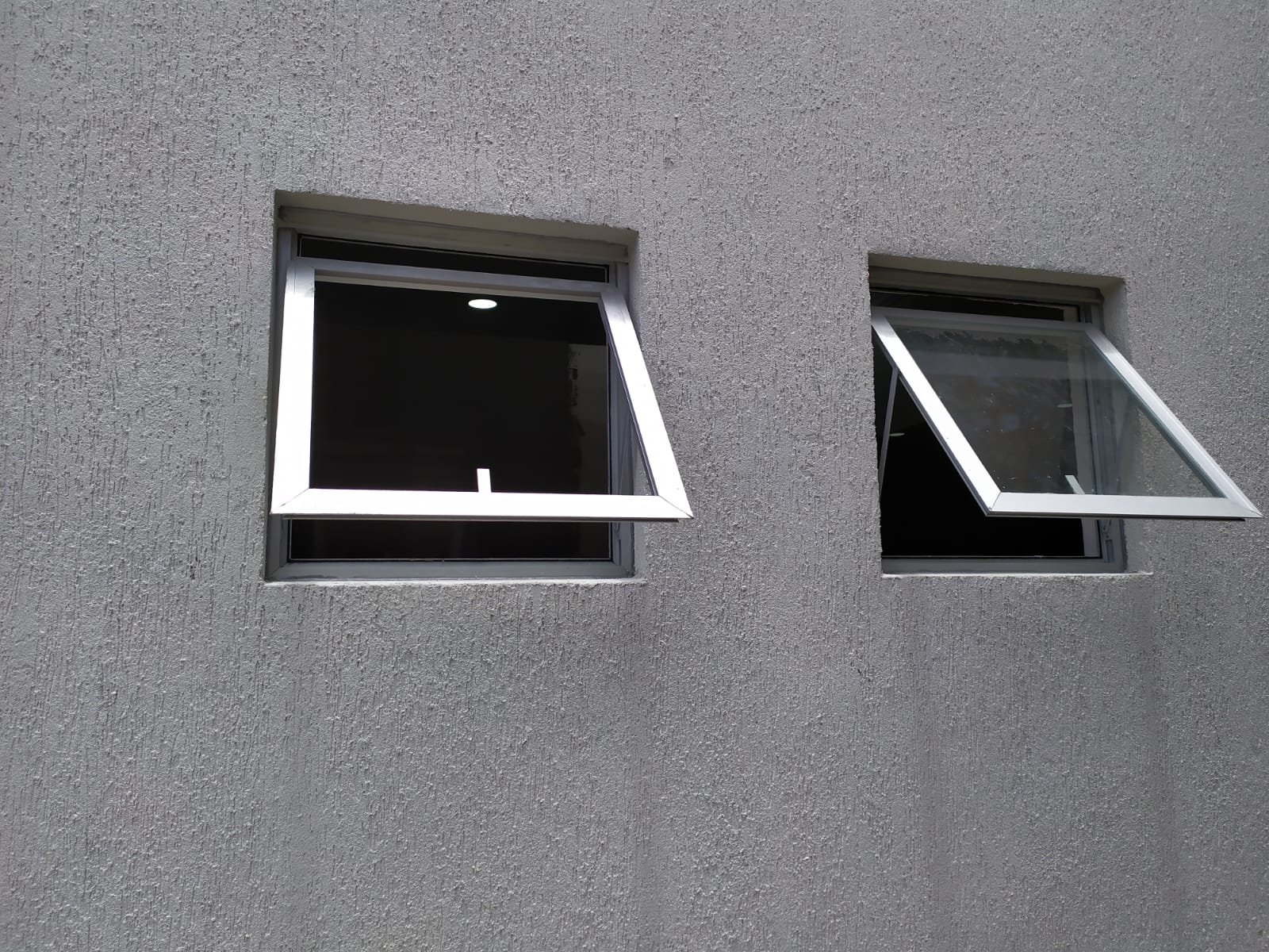 Ventanas proyectantes de aluminio en fachada con revoque texturado · MÁS VIDRIOS