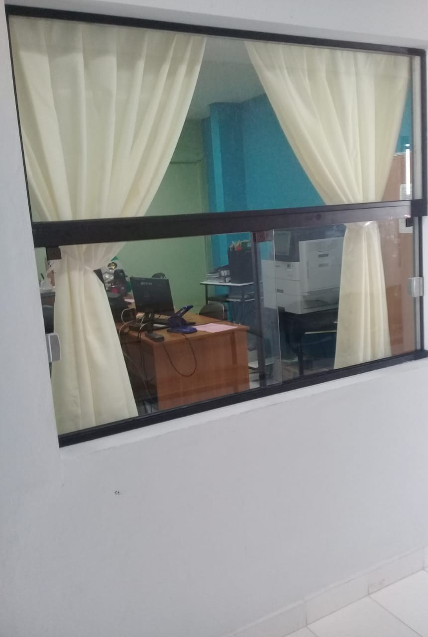 Ventanilla de atención con hoja corrediza y marco de aluminio negro sobre pared blanca · MÁS VIDRIOS