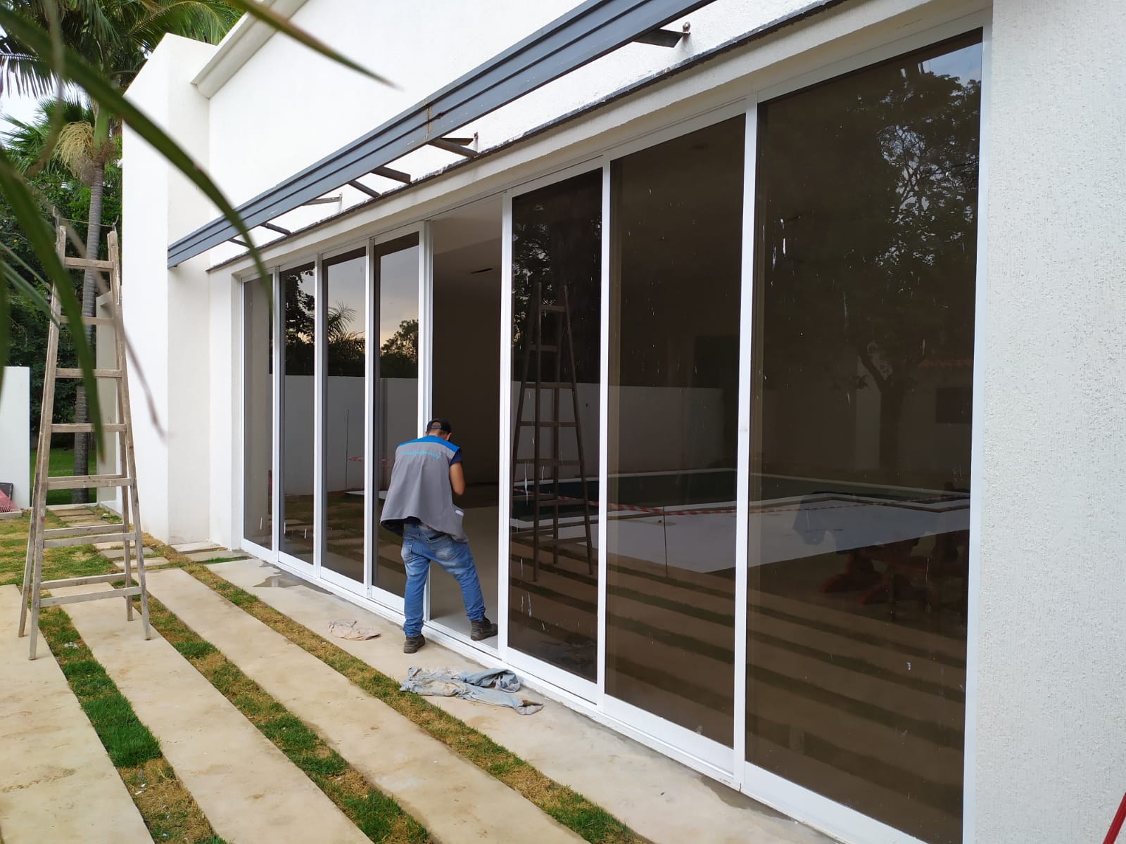 Cerramiento de vidrio con aluminio blanco en galería junto a piscina · MÁS VIDRIOS