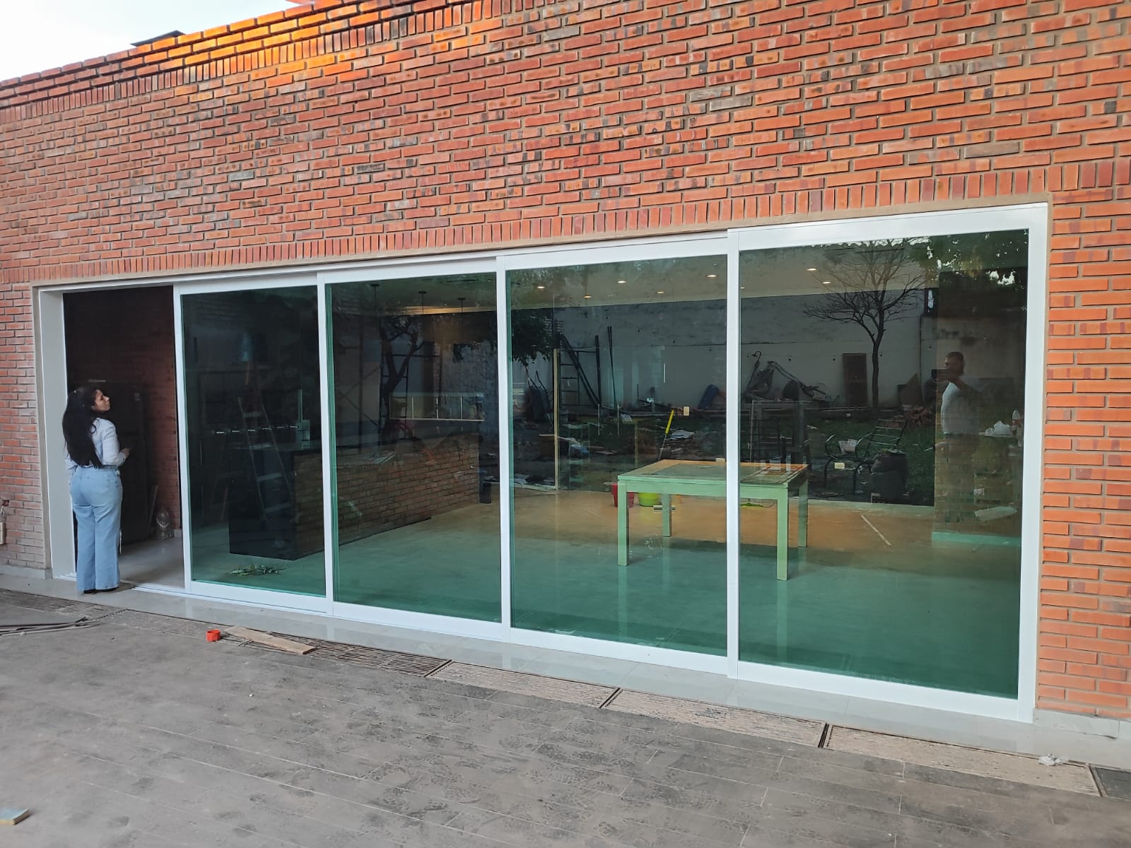 Vidriera corrediza en fachada de ladrillo visto de local comercial · MÁS VIDRIOS